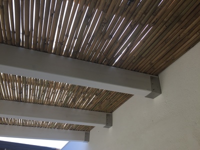 Vista interna ravvicinata di una veranda in legno lamellare Abete impregnata bianco con cannucciato a vista, realizzata a Marsala (TP).