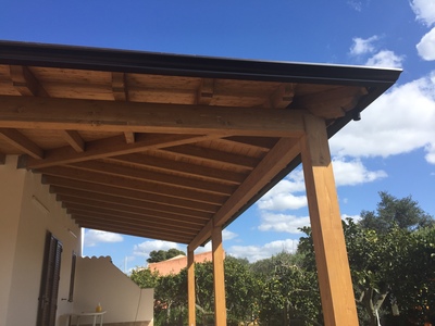 Vista laterale di una veranda ad angolo  in legno lamellare Abete, realizzata a Marausa (TP).