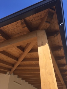 Vista frontale ravvicinata di una veranda ad angolo  in legno lamellare Abete, realizzata a Marausa (TP).