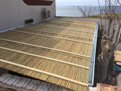 Vista superiore di tettoia in legno lamellare con doppio strato di canne di bambù e policarbonato alveolare trasparente, realizzata a Favignana (TP).