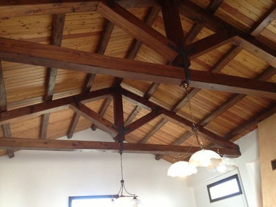 Vista interna della ristrutturazione del tetto di magazzino con capriate, arcarecci e perline in legno Larice Siberiano, realizzata a Trapani (TP)