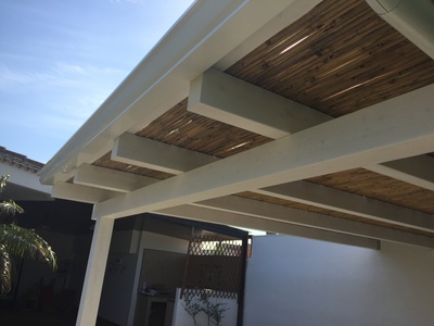 Immagine particolare di una veranda in legno lamellare Abete impregnata bianco con cannucciato a vista, realizzata a Marsala (TP).