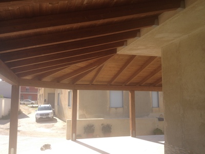 Vista interna di una tettoia in legno lamellare Abete e perline con disegno costruttivo particolare a 1 falda con 2 diagonali, con copertura finale di  tegole,  realizzata a  Marsala (TP)