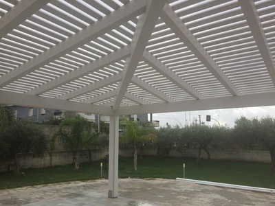 Vista interna di veranda ad angolo con doghe e policarbonato alveolare, realizzata a Marsala (TP).