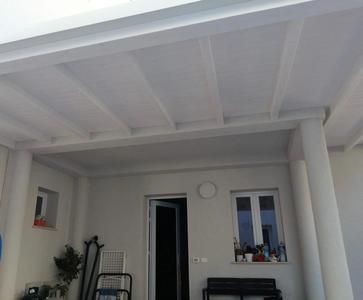 Vista interna di una tettoia in legno lamellare impregnata bianca, realizzata a San Vito( TP)