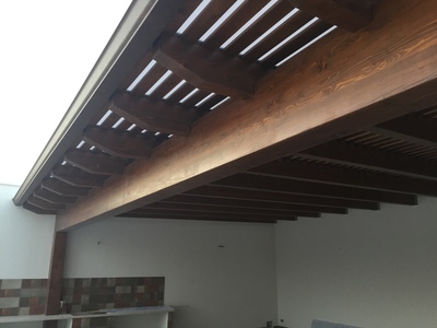 Vista frontale di tettoia in legno con doghe policarbonato compatto, realizzata a Petrosino (TP).